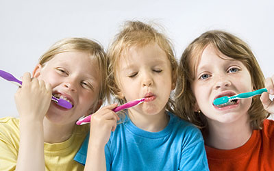 3 kids brushing teeth