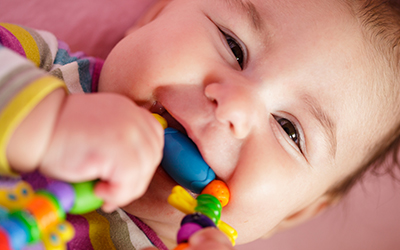 A baby chewing on a teething ring