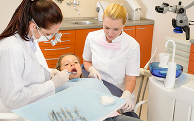 Dental assistant with a young child sitting in a dental chair