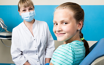A young girl in a dental office with a doctor