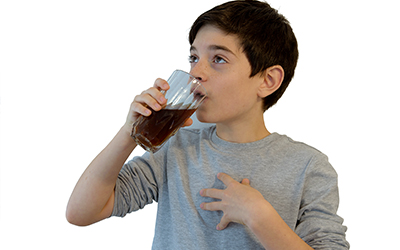 child drinking a glass of soda