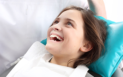 A young girl sitting in a dental chair
