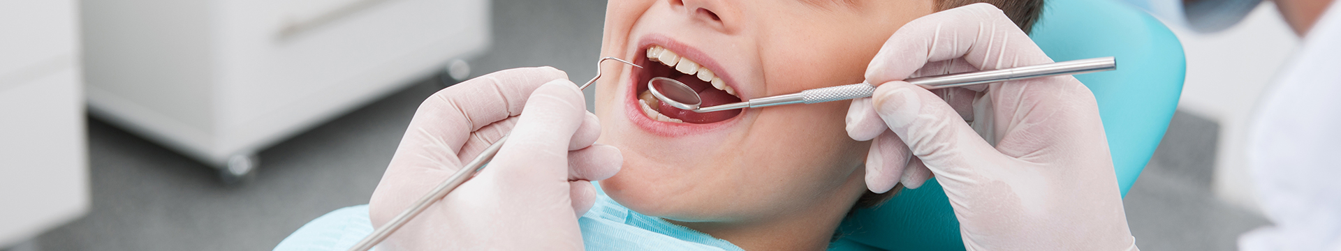 Cropped images of kid in dental chair smiling
