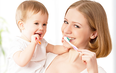 Mom and baby brushing teeth
