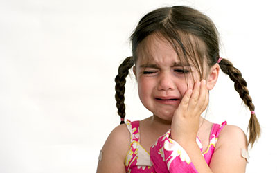 Young child crying due to tooth pain