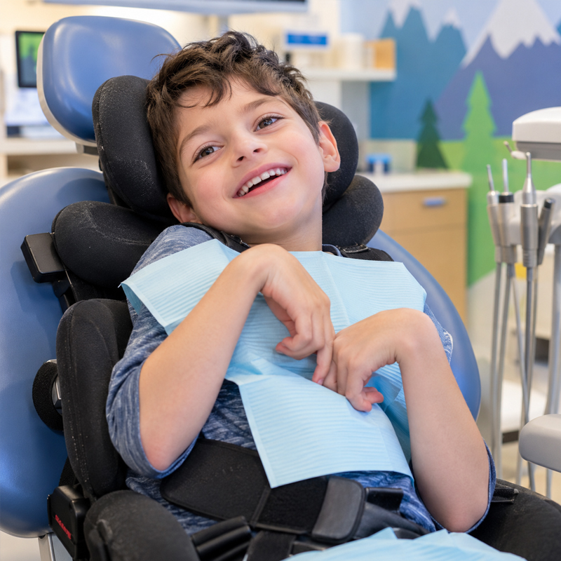 Child with cerebral palsy smiling comfortably in a pediatric dental chair during a dental visit