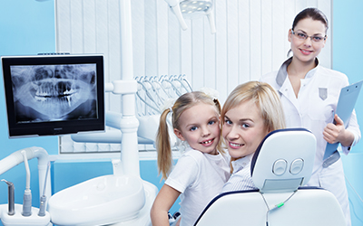 Mom and daughter sitting in a dental chair